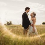 Couple in field at sunset wedding