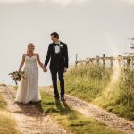 Bride and groom walking on country path