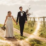 Bride and groom walking outdoors on wedding day.