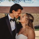 Couple smiling on wedding day outdoors.