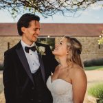 Bride and groom smiling outside wedding venue