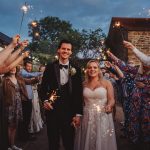 Bride and groom with sparklers at wedding celebration.