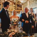 Bride walking down aisle in elegant wedding ceremony.