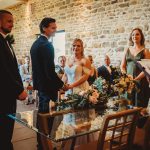 Couple getting married in a stone-walled venue.