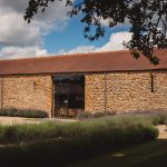 Rustic stone barn with lavender garden outside.