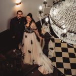 Couple on staircase under chandelier at wedding