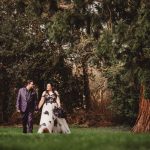 Couple walking in forest, holding hands.