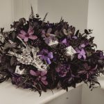 Floral arrangement with purple flowers and silver decor.