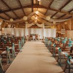 Rustic wedding venue decorated with fairy lights and chairs.