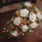 Rustic bouquet with white roses and pinecones