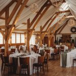 Elegant rustic wedding reception venue with wooden beams.