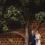 Bride and groom under a magnolia tree.