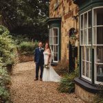 Wedding couple by a rustic stone building