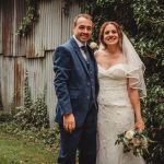 Bride and groom smiling outdoors at wedding