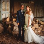 Bride and groom in rustic setting with logs.