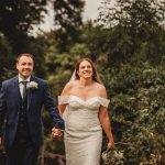 Bride and groom walking joyfully outdoors.