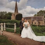 Bride and groom outside church on cloudy day.