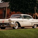 Vintage white car with wedding ribbons.