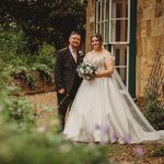 Bride and groom smiling in garden setting