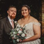 Bride and groom smiling with bouquet