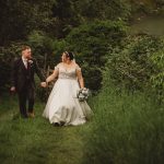 Bride and groom walking in lush green garden