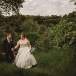 Bride and groom walking in lush green forest