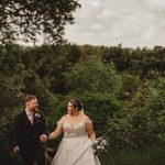 Bride and groom walking in lush green garden