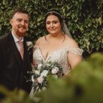 Bride and groom smiling in garden setting