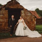 Bride and groom in front of rustic building