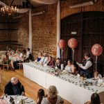 Wedding reception with guests seated at tables.