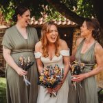 Bride and bridesmaids laughing, holding bouquets