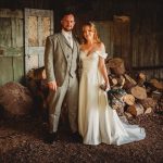 Bride and groom in rustic wood setting.