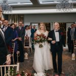 Bride walking down aisle with her father.