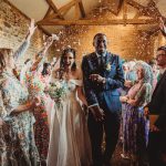 Newlyweds celebrating with guests indoors.