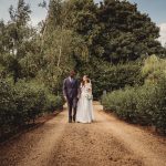 Bride and groom walking in a garden path