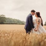 Couple in wheat field on wedding day