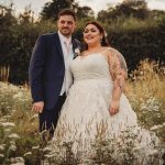 Bride and groom in a meadow with flowers.