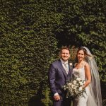 Bride and groom in garden on wedding day.