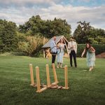 Group playing outdoor ring toss game on grass.