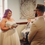 Bride reading vows during intimate wedding ceremony.