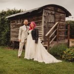 Couple posing by rustic wooden cabin