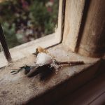 White rose boutonniere on rustic windowsill