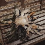 Rustic dried flower bouquet on wooden bench.