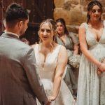 Bride and groom exchanging vows at rustic wedding.