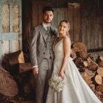 Wedding couple posing in rustic barn setting.