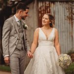 Smiling couple holding hands on wedding day