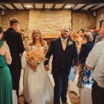 Bride and groom walk down wedding aisle