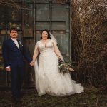 Bride and groom holding hands outdoors.