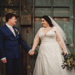 Bride and groom holding hands outdoors.