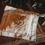 Three rings on embroidered handkerchief, wooden table.